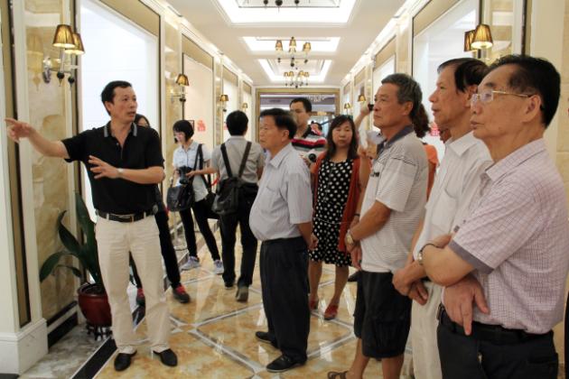 圖3、宏陶市場總監(jiān)霍達炎（左一）在為參觀者介紹釉面磚展示空間.jpg